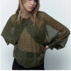 Semi-sheer shirt with round neck, wide long sleeves.  Back button closure.